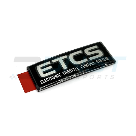 a gel based sticker that says ETCS Electronic Throttle Control System with a black background and a red adhesive tab on a white backing with a DNST Motorsports watermark